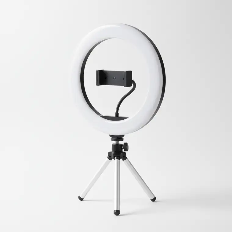 Kobieta wykonująca zdjęcia makijażu w małym mieszkaniu, używająca ring light 30 cm ustawionego na biurku, pokazująca idealne oświetlenie twarzy